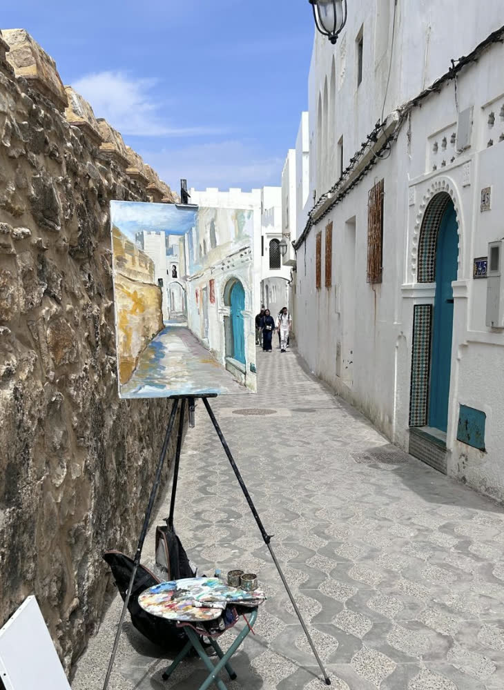 Chevalet installé dans une ruelle blanche pour peindre sur le motif